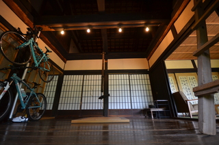 天井は梁が見え、障子て仕切られた板の間に自転車が2台掛けられているおしゃれな和室の写真