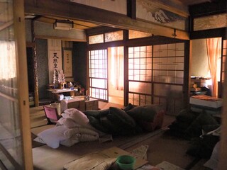 右上に和風の照明が設置され、布団が置かれた和室の写真