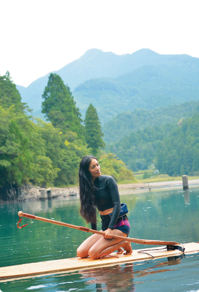 山に囲まれた湖でサップをしている女性の写真