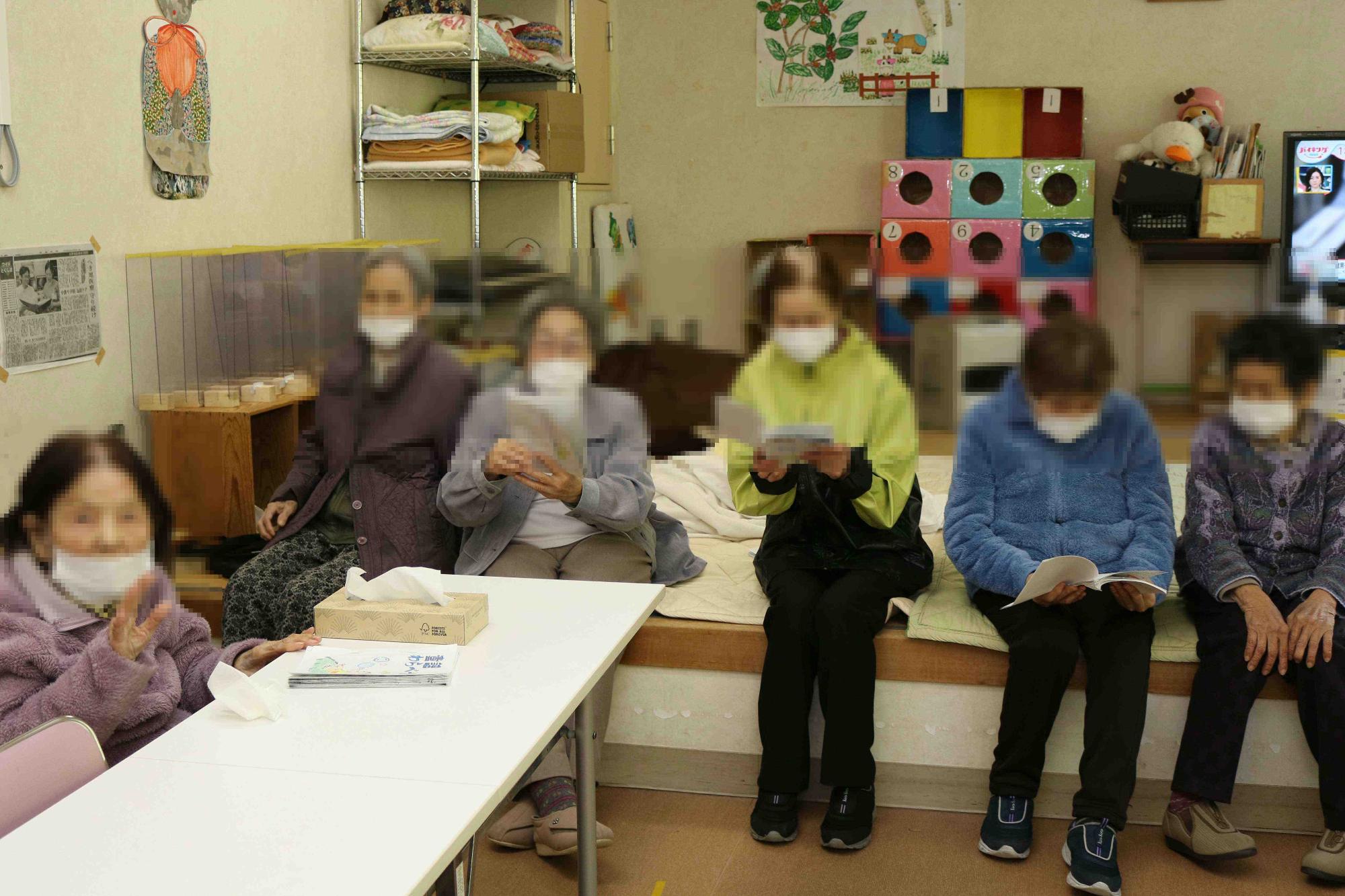 高齢の女性が本を読んでいる様子の写真
