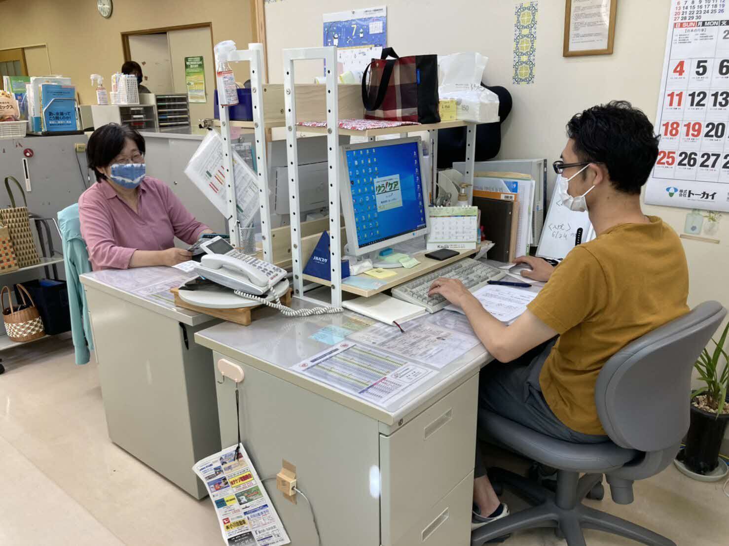 向かい合うように机を並べ業務を行っている2名の職員の写真