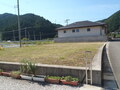 隣に家がある四角い基礎の区画1南川312-6の写真