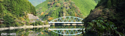 木頭助のダム湖の写真。周りの山々と水色の橋が湖面に映っている