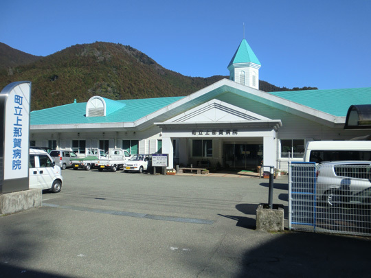 町立上那賀病院の看板が出入り口に設置され、エメラルドグリーンの屋根で白い外壁の町立上那賀病院の外観写真