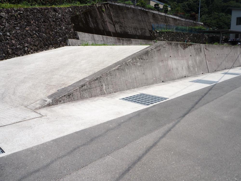 背の高い石壁の手前側に広々とした空き地が広がっている写真