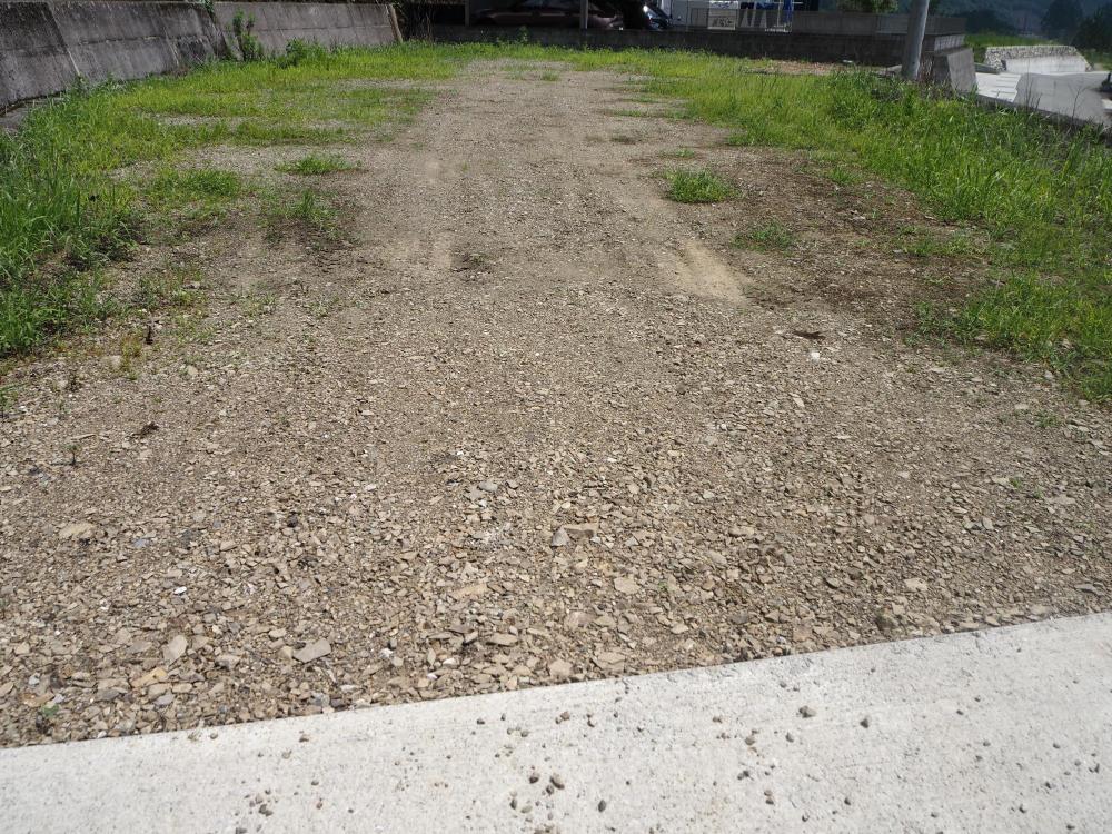 進入路を上がったところにある砂利敷の宅地の写真