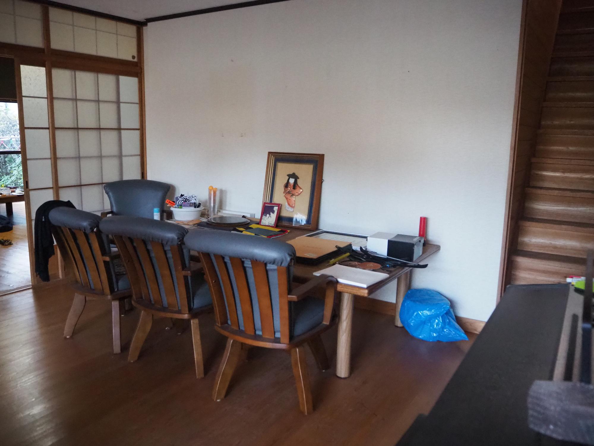 二階へ行く階段やテーブルセットが置かれた洋室の写真