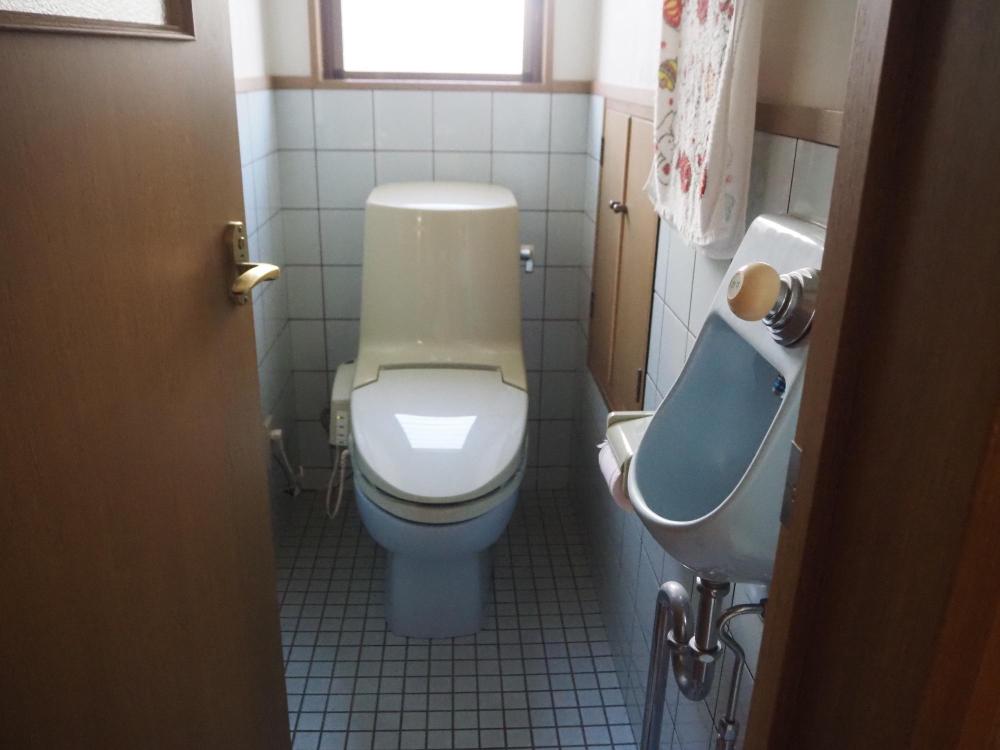 水色のタイル貼りの洋式トイレ