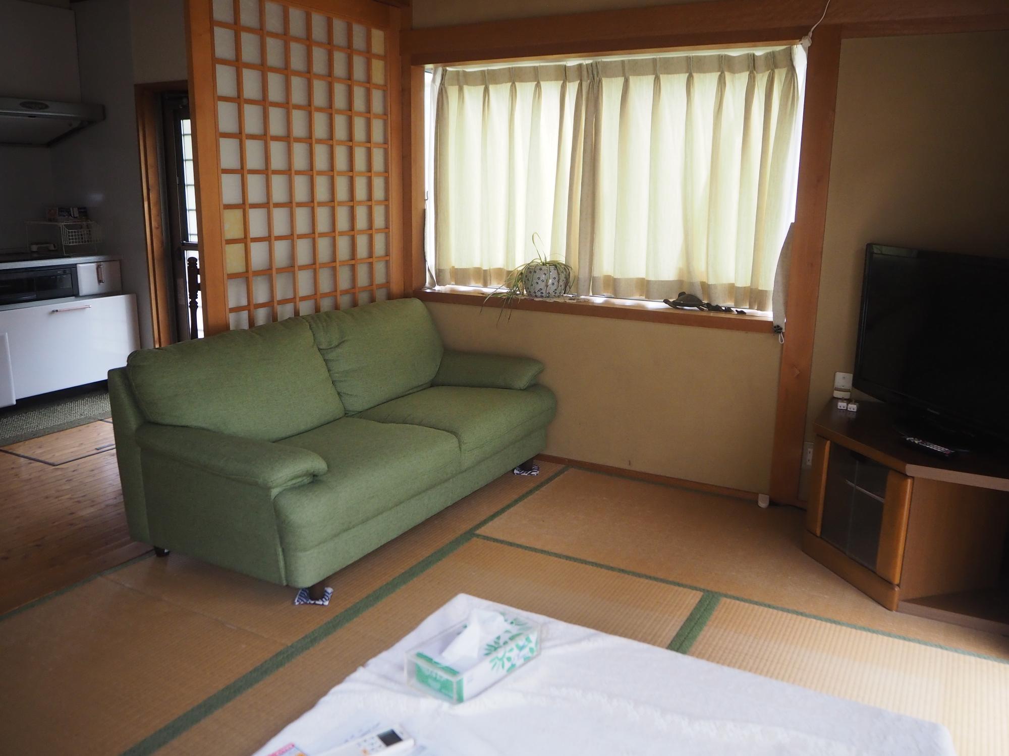 和室にテレビとソファが置かれている居間の写真