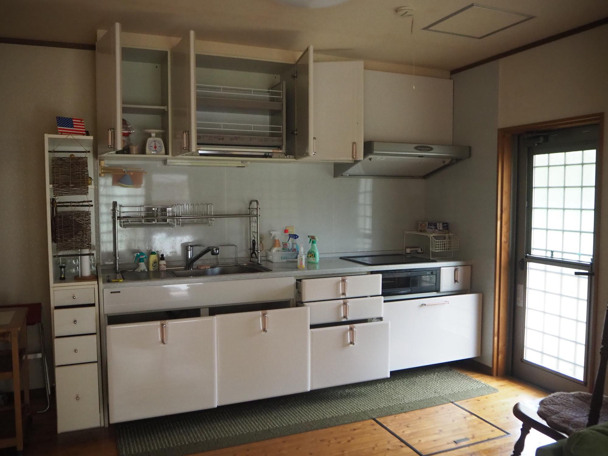 システムキッチンが有り横には勝手口が有る台所の写真