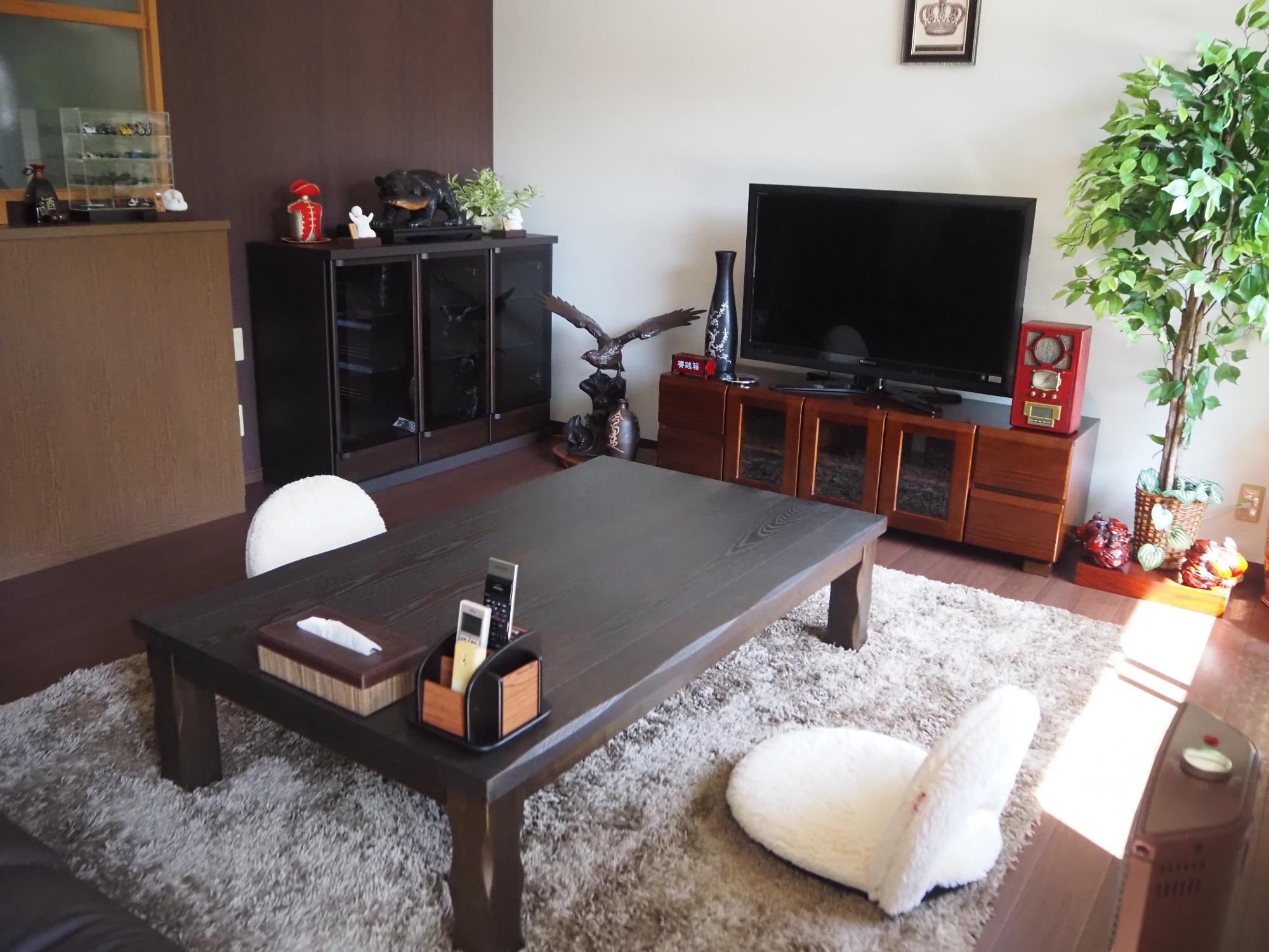 テレビ、ブラウンの家具とグレージュのラグが敷かれた洋間