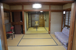 ソファーが置かれた和室の奥に窓のある和室の写真