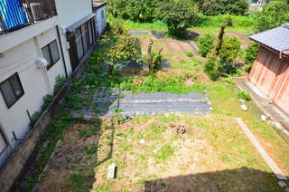建物と建物の間にある畑を高い位置から撮影した写真