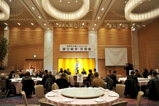 那賀町近畿ふるさと会 設立総会・交流会と書かれた幕が張られ金屛風が設置されたステージに立った人が挨拶をしている写真