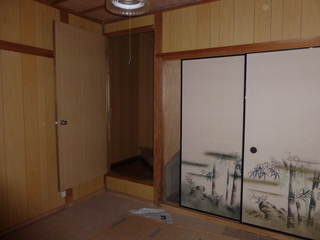押し入れが備え付けられた畳の敷かれていない和室の写真