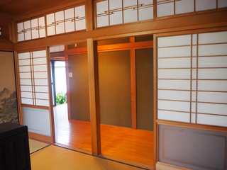 和室にある下部分がすりガラスになっている障子戸の奥に廊下がある写真