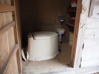 ポータブル洋式トイレが設置された汲み取り式トイレの写真