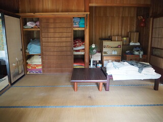 押入に布団が収納され、テーブルが置かれた和室の写真