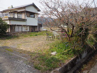空き地の左側に2階建ての住宅が写っている写真