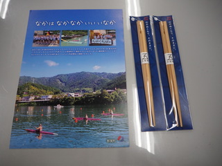 那賀町の山と池が映ったチラシが左に、木頭朱杉を用いた五稜箸が2膳右手に並べられている写真