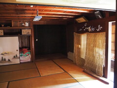 天井に蛍光灯がついており、奥に押し入れがある畳敷きの和室の写真