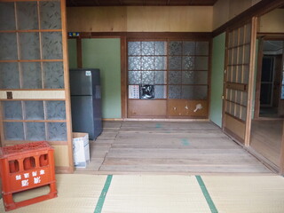 畳が張られている和室の部屋から床板が見えガラスの引き戸で仕切られている部屋を撮影した写真