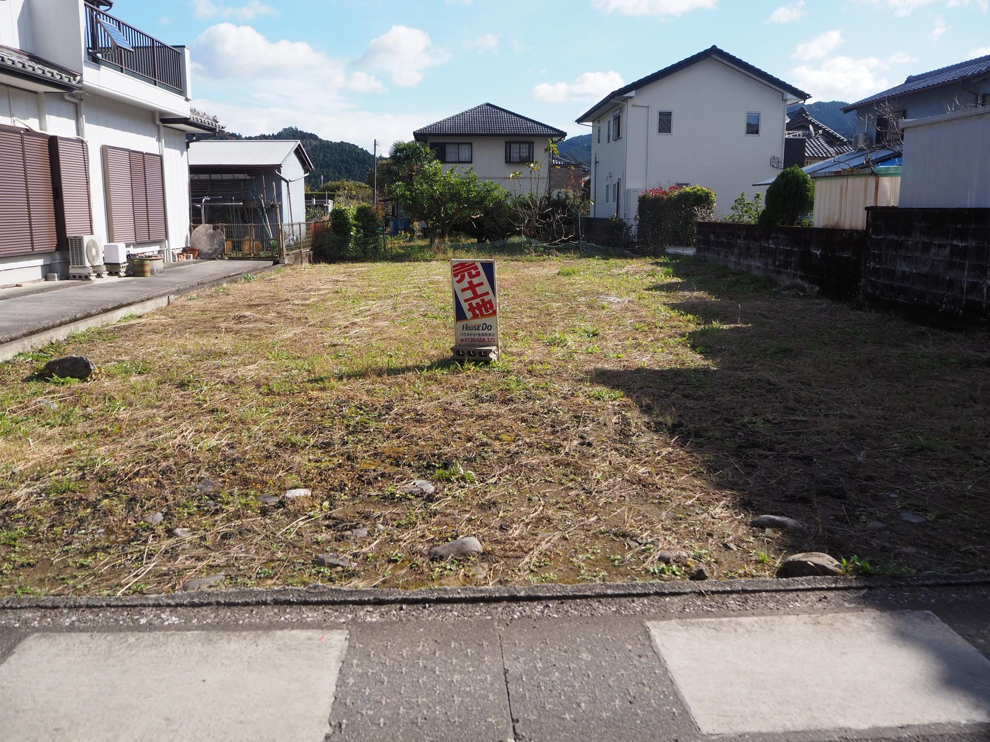 敷地の中央に「売土地」と書かれた看板が置かれた空地の写真