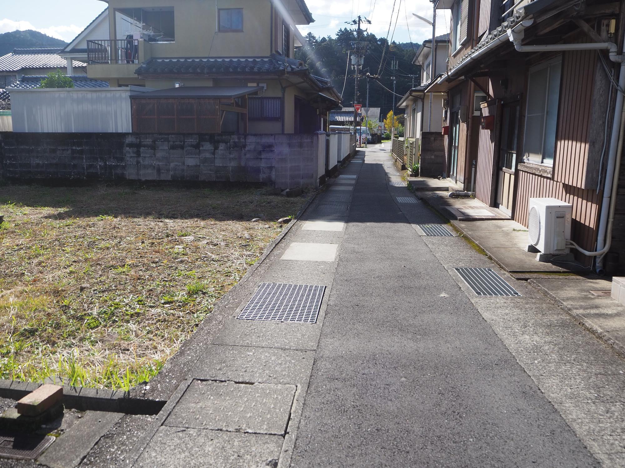 細い道路沿いにある空地の写真